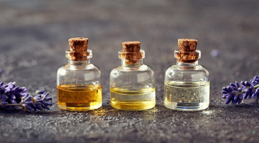 Three small glass bottles filled with essentials oils.