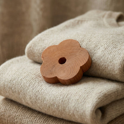 Thin cedarwood flower placed among folded clothes for natural wardrobe protection
