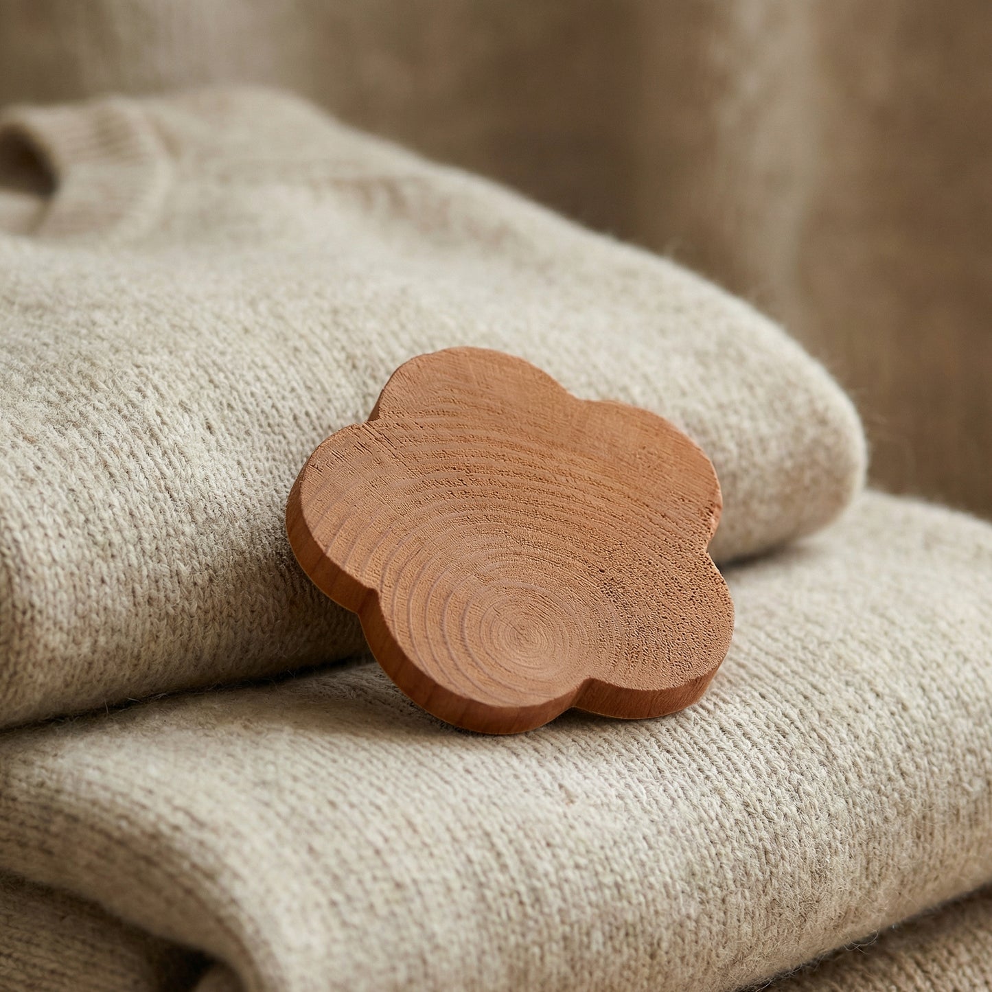 Thin cedarwood flower without hole placed among folded clothes for natural wardrobe protection
