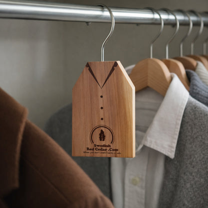 Cedarwood clothes hanger hanging in a wardrobe to help protect clothes from moths